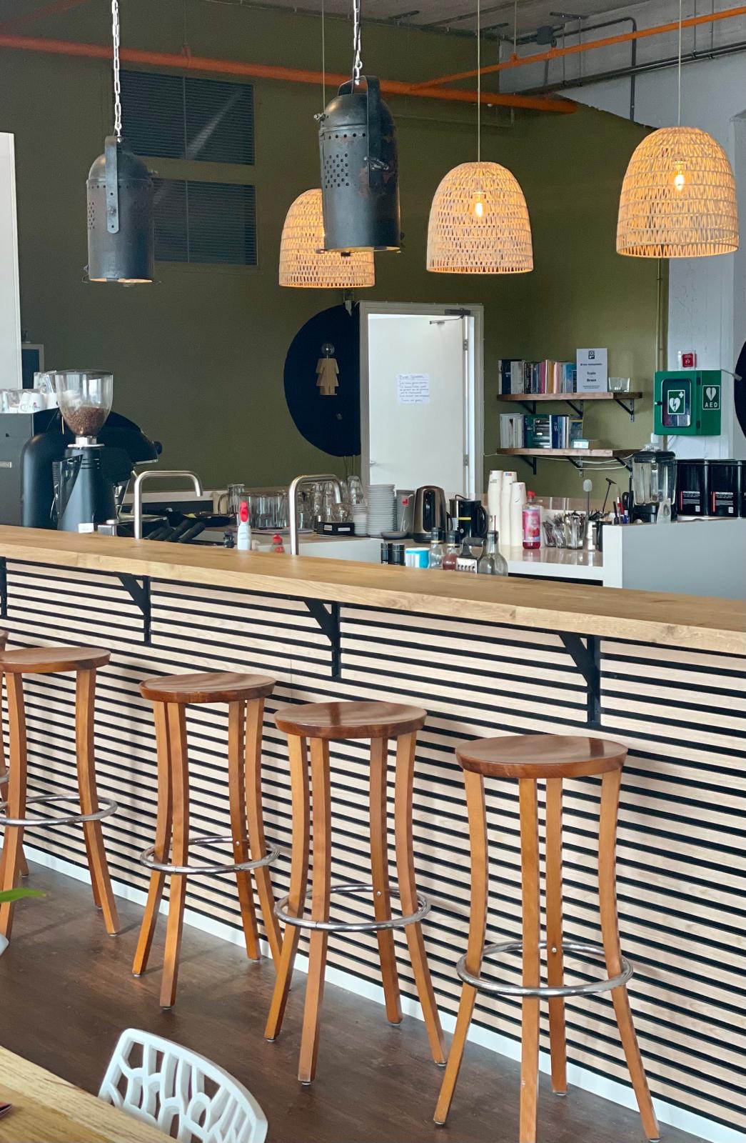 De koffiebar van B-Food met houten krukken en de espressomachine